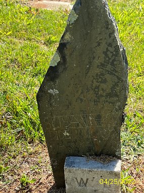 Susanbroken Susan's marker has separated from the ground and is currently resting the foot marker of William Briles of Row 5. Susan Garren Died July 2, 1895